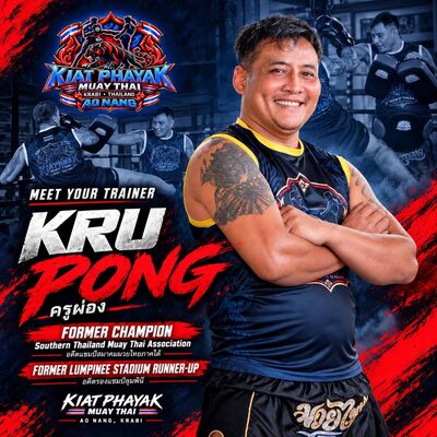 Kru Pong, arms crossed, smiling in the ring