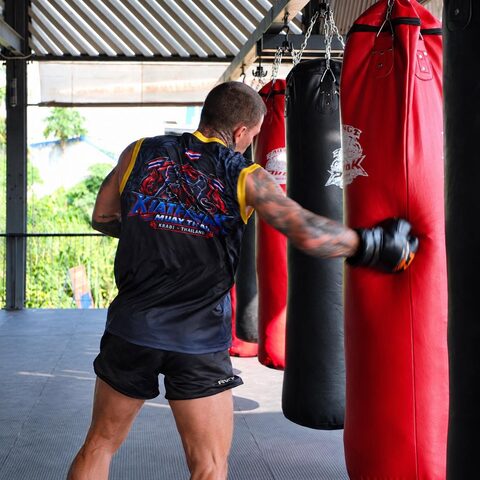 A student works the heavy bag under the roof of the gym